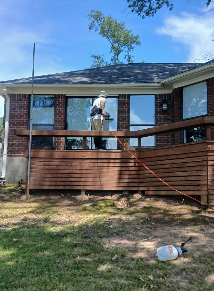 man on patio washing window